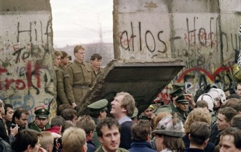Foto de personas y militares en la caída del muro de Berlín