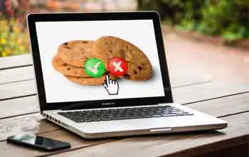 Par de galletas con dos opciones de aceptar o rechazar en la pantalla de laptop sobre mesa de madera