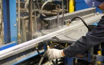 Hombre trabajando en fabrica con maquina extrusora de metal en laminas