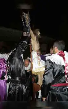 Grupo de personas en procesión con Jesucristo en una cruz