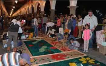 Personas realizando alfombras coloridas para procesión de semana santa