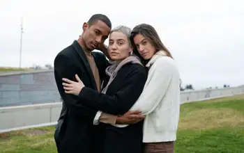 Tres personas abrazadas en relación poliamorosa al aire libre