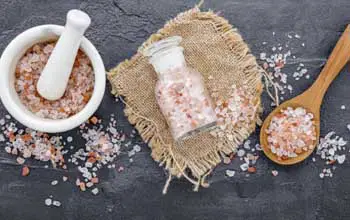 Sal rosa del himalaya con sal blanca en cuchara de madera y recipientes