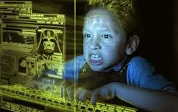 Niño jugando videojuegos en la noche con iluminación amarilla en teclado y pantalla