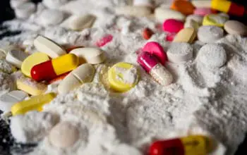 Diferentes tipos de drogas en polvo y en píldoras de colores sobre una base oscura