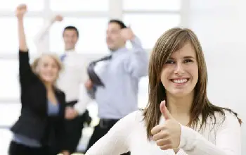 Mujer emprendedora feliz al fondo sus compañeros de trabajos celebrando en una oficina