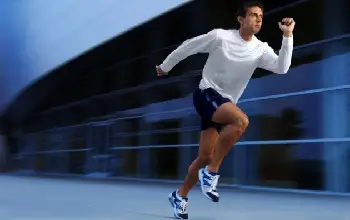 Hombre con ropa deportiva haciendo carrera de alta intensidad en un fondo borroso