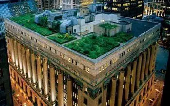 Vista aérea de edificio con casa en la azotea con plantas en una ciudad