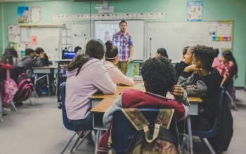 Foto de un salón de clases donde el profesor esta enseñando un tema a unos estudiantes adolescentes