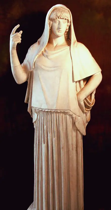 Estatua de la diosa griega, quien tiene una mano levantada y la otra apoyada en su cintura
